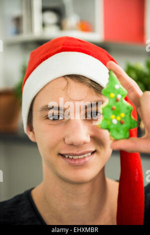 Ritratto di un giovane che mostra il biscotto dell'albero di natale, Monaco, Baviera, Germania Foto Stock