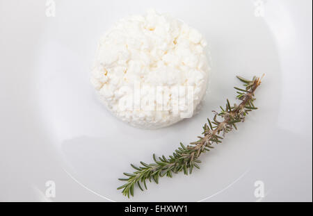 Granulati di formaggio al di sopra della piastra con un ramo di rosmarino. Isolato su bianco Foto Stock