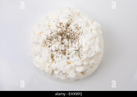 Granulati per la ricotta con erbe aromatiche. Isolato su bianco Foto Stock