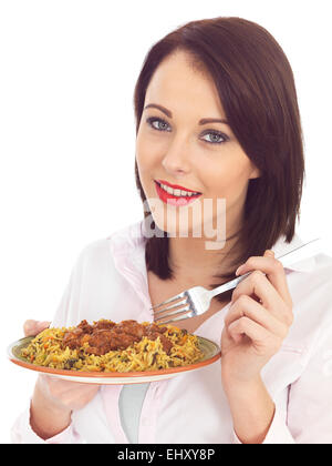 Attraente giovane donna mangiando carne di agnello rogan josh Curry Indiano Foto Stock