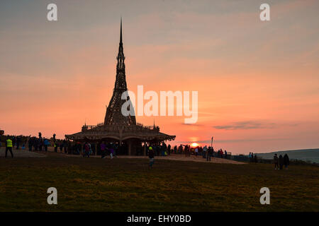 Londonderry, Irlanda del Nord. Il 18 marzo, 2015. Regno Unito meteo. Sunset over Burning Man Tempio. La gente visita il Burning Man tempio in Londonderry al tramonto. Creato da un artista californiano David migliori, il 75 in legno a telaio tempio insieme con cimeli e i messaggi lasciati dalle persone durante questa settimana, sarà bruciato ceremonially sabato marzo 21st. Credito: George Sweeney/Alamy Live News Foto Stock