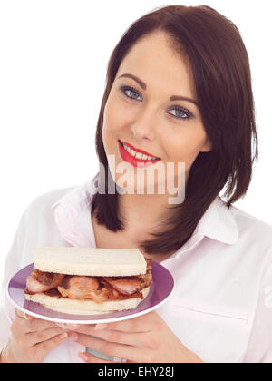 Attraente giovane donna di mangiare un panino pancetta Foto Stock