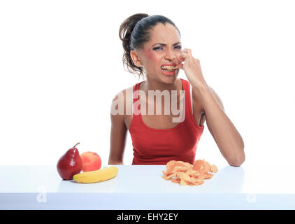 Bella giovane donna scegliere tra frutta e patate fritte Foto Stock