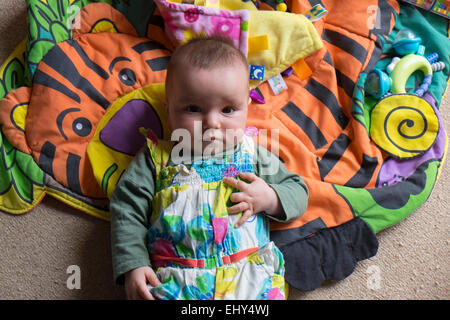 8 mese fa Baby girl, giacente sul piano Foto Stock