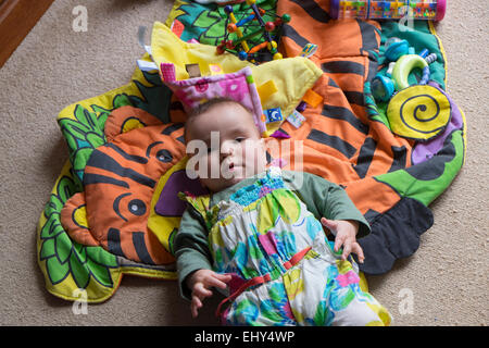 8 mese fa Baby girl, giacente sul piano Foto Stock