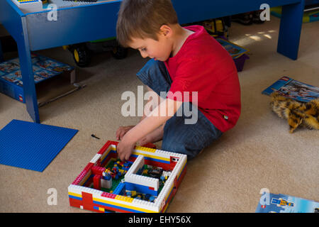 Ragazzo di età compresa tra i quattro anni di gioco con Lego blocchi per costruzioni in camera da letto Foto Stock