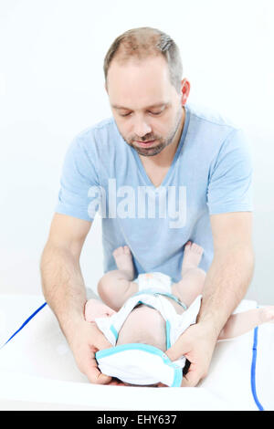 Padre cambiando pannolino per bambini Foto Stock