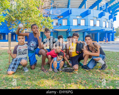 Un gruppo di giovani ragazzi cubani che giocavano un pick up gioco di baseball, rappresentano con la loro bat, sfera e guanti a l'Avana. Foto Stock