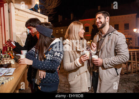 Gruppo di amici di stallo a Mercatino di Natale Foto Stock