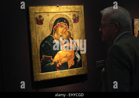 Praga, Repubblica Ceca. Il 18 marzo 2015. Un visitatore esamina il Cretan icona della Madre di Dio Glykophilousa a partire dalla seconda metà del XV secolo e la prima metà del XVI secolo durante la fase di apertura della mostra la tradizione bizantina attraverso i secoli a Praga, Repubblica Ceca. La mostra presenta una selezione eccellente di Greco icone ortodosse provenienti dalle collezioni del Kondakov Istituto Archeologico (Praga) e il Museo dell'icona russa (Mosca) corre fino al 13 maggio 2015, in Strahov Picture Gallery. Foto Stock
