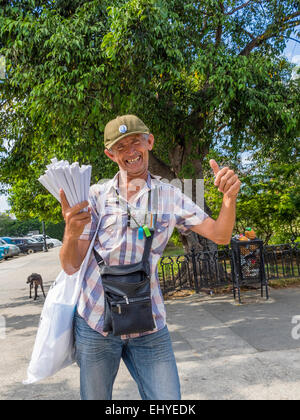 Un vecchio ispanico maschio fornitore di arachidi pedali è mercanzia in Havana Vieja. Le arachidi sono confezionati nel tradizionale modo cubano. Foto Stock