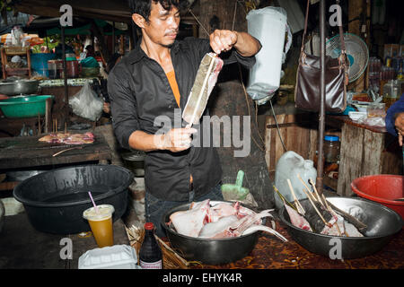 Mercato del granchio in Kep Cambogia. Tradizionale occupazione per fare una vita. Un uomo di cuochi e vende pesce all'aperto in un ristorante locale Foto Stock