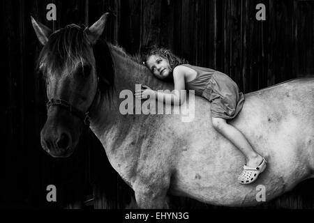 Ragazza seduta senza bareback su un cavallo Foto Stock