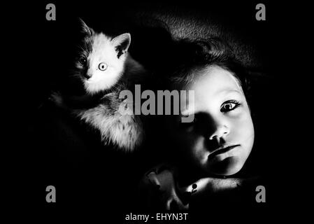 Ritratto di una ragazza sdraiata accanto al suo gatto Foto Stock