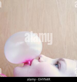 Ritratto di una ragazza soffiando una bolla di bubblegum Foto Stock