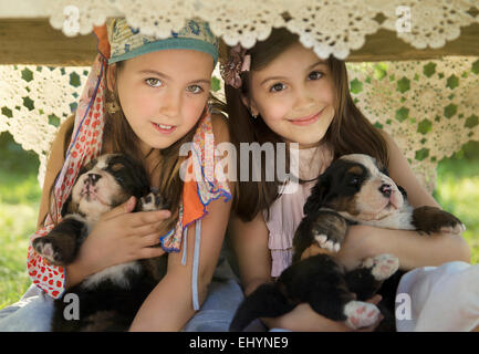 Due ragazze seduta con i cuccioli Foto Stock