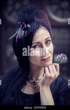 Ritratto di una donna tenendo un fiore Foto Stock