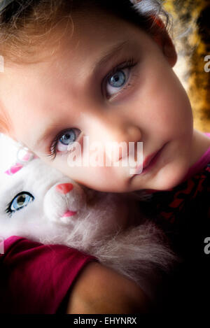Ritratto di una ragazza che coccola un giocattolo morbido gatto Foto Stock