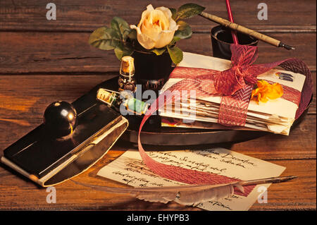 Vecchi utensili di scrittura, intorno al 1900, con quill, penna stilografica e lettere su una tavola di legno Foto Stock