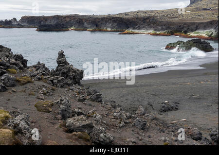 Le onde che lambisce la spiaggia di sabbia nera sull'isola vulcanica di Jan Mayen Foto Stock