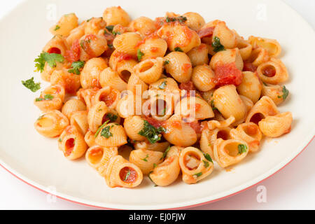 Gomiti gomito gusci di pasta si lancia in arrabbiata pomodoro aglio e peperoncino salsa e servite con prezzemolo tritato Foto Stock