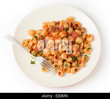 Gomiti gomito gusci di pasta si lancia in arrabbiata pomodoro aglio e peperoncino salsa e servite con prezzemolo tritato Foto Stock