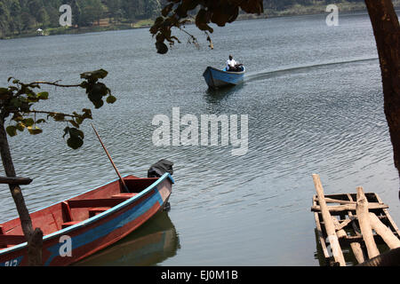 Un uomo che cavalca una barca sul Lago Bunyonyi e, Africa più profondi di acqua fresca corpo in Uganda occidentale Foto Stock