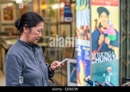 Donna vietnamita la vendita di stampe e poster nel quartiere vecchio di Hanoi. Foto Stock