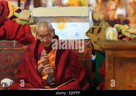 DREPUNG, Tibet, Cina - 19 ottobre: tibetano monaco buddista scuote una piccola campana-Sutra Sala della Hall Coqen nel Drepung monast Foto Stock