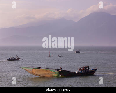 Barche da pesca, lavorando a prua, scoop truccate reti, Da Nang Bay, sfondo di montagne, Da Nang, Vietnam, SE Asia, Sud Est Asiatico, in barca Foto Stock