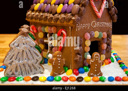 Chiudere orizzontale di una casalinga casa di panpepato decorato per il Natale con alberi di Natale e di neve. Foto Stock