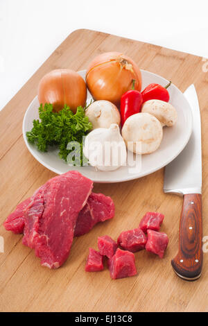 Bistecca di manzo e verdure miste su un tagliere pronto per preparare la cena Foto Stock