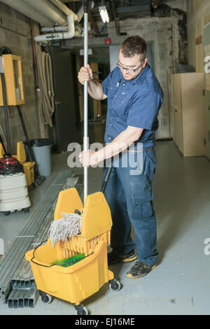 Veterano che la pulizia del pavimento con la sua mop Foto Stock