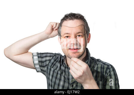 Foto di un uomo a mettere su una maschera di se stesso. Foto Stock