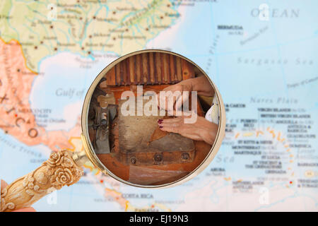 Guardando in su di una donna che fa di sigari a Cuba con una mappa dei Caraibi Foto Stock