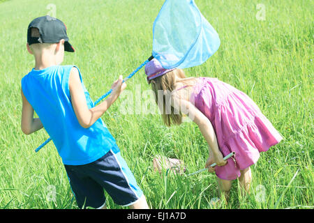 I bambini che cercano di catturare qualche butterfly con net. Foto Stock