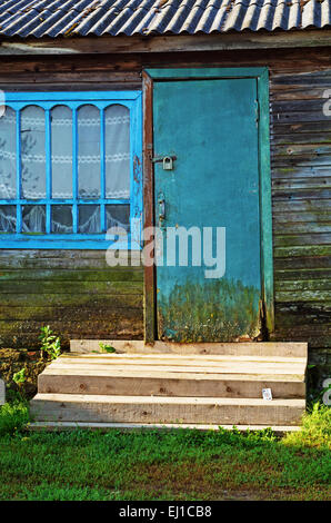 Casa di villaggio con porta carta persa sulla veranda in legno fasi. Foto Stock