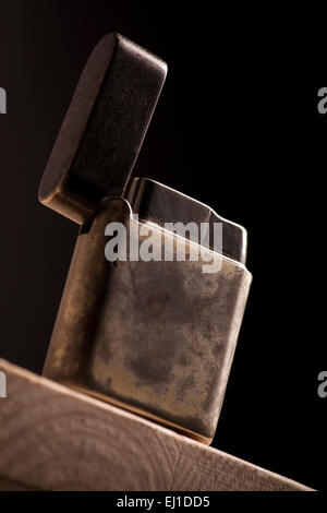 Colore close-up shot di un accendino vintage su uno sfondo scuro. Foto Stock