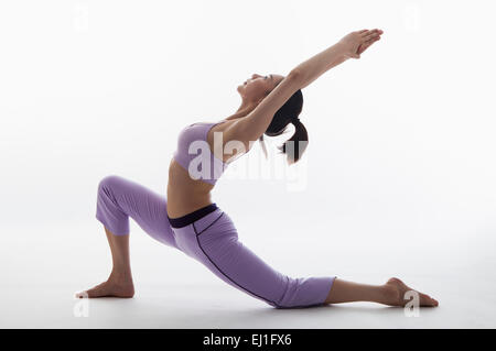 La donna a praticare yoga e piegatura oltre all'indietro con le mani insieme Foto Stock