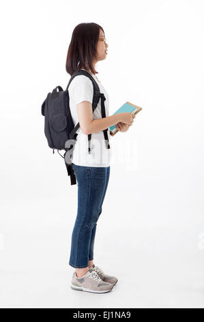 Ragazza adolescente permanente e la holding libri con profilo Foto Stock