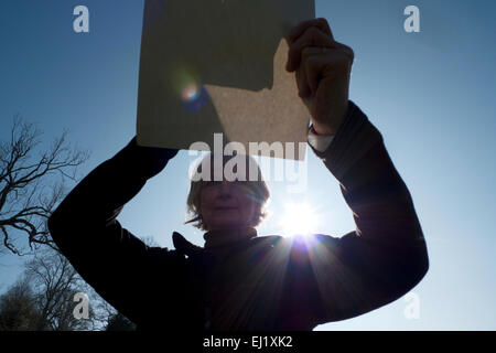 Carmarthenshire, Wales, Regno Unito. Venerdì 20 marzo 2015. Vivien Kersey viste le eclissi solare a 9:48 del mattino in modo sicuro attraverso un foro a punta di spillo tenuto sopra un foglio di carta bianca nel suo giardino in Carmarthenshire, West Wales UK. Il Galles è uno dei posti migliori per visualizzare l'evento raro a causa di azzurro del cielo. Kathy deWitt/AlamyLiveNews Foto Stock