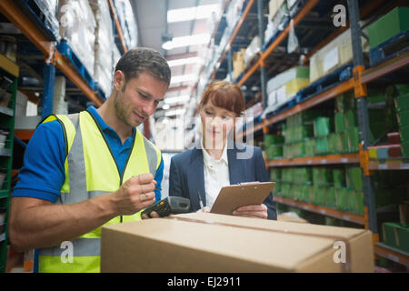 Il lavoratore e il manager pacchetto di scansione in magazzino Foto Stock