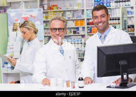 Team di farmacisti sorridente in telecamera Foto Stock