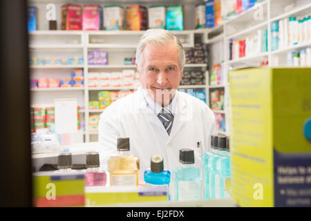 Senior sorridente al farmacista in piedi dietro un ripiano Foto Stock