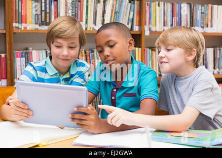 Carino gli studenti usando computer tablet in libreria Foto Stock