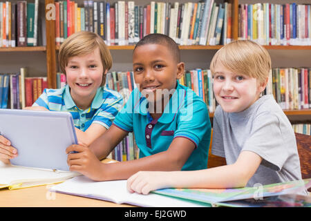 Carino gli studenti usando computer tablet in libreria Foto Stock