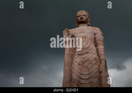 Il 80 piedi-High standing statua del Buddha di pietra arenaria con supporto di Thailandia persone. Sarnath, India. Foto Stock