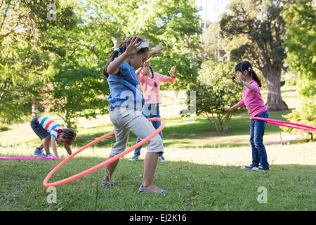 Piccoli amici a giocare con hula hoops in posizione di parcheggio Foto Stock