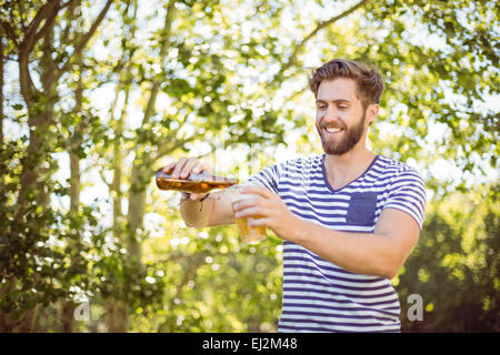 Hipster riversandosi una birra Foto Stock