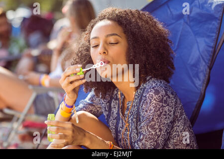 Carefree hipster soffiare bolle in tenda Foto Stock